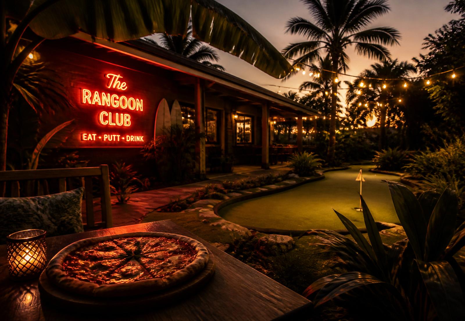 The Rangoon Club patio at dusk with a coral neon sign, string lights and a putting green